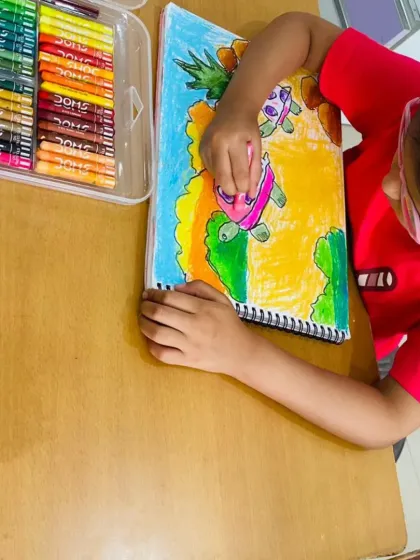 Look at the concentration as this student brings a friendly tortoise to life with oil pastels. We work on staying within the lines and choosing bright, happy colors to make the character stand out.
