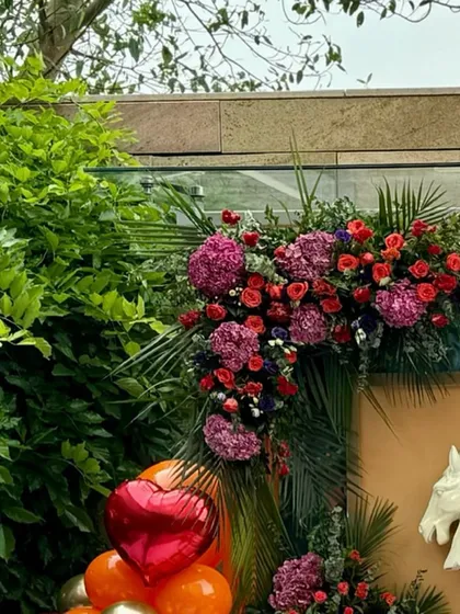 The corner of the baby shower backdrop, showing the integration of florals, balloons, and a decorative horse bust.