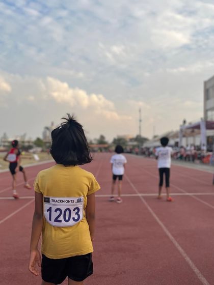 A young athlete looks towards the finish line, embodying the relentless pursuit of greatness we celebrate on World Athletics Day.