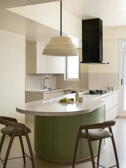 This spacious and fun kitchen was designed around the circular layout of the living room. It features a curved green island that serves as both a cooking and breakfast area, with a large dome light overhead.