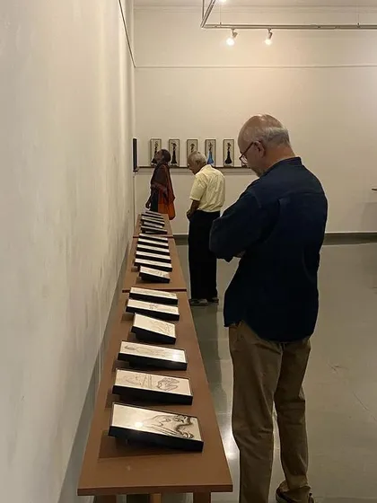 A visitor closely inspecting the series of reverse paintings on glass.
