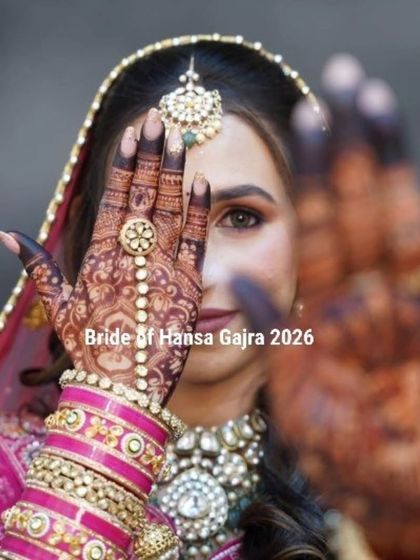 A creative and artistic shot of the bride. She peeks through her mehendi-covered hand, drawing attention to the intricate details of the henna and her beautiful eyes.