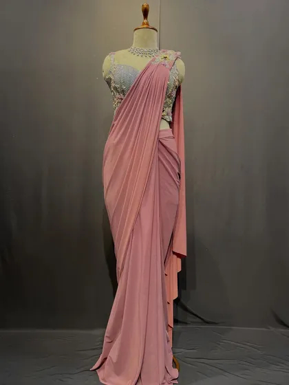 Pastel whispers and intricate blooms. This soft pink drape saree with a silver embroidered blouse is a story of timeless grace.