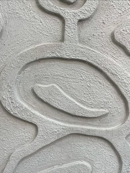 A detailed close-up of a white textured piece for a client in Hyderabad. The design features soft, interlocking lines and a rough, stone-like surface finish.
