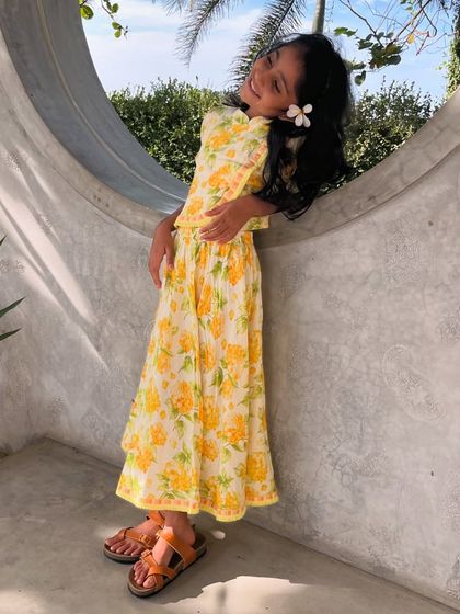 Sunshine vibes and happy twirls. This little one is rocking her yellow floral dress, adding a splash of sunshine wherever she goes.