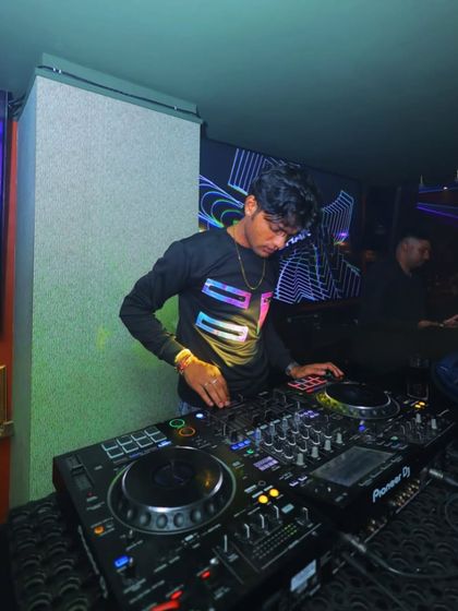 Spinning tracks and spreading joy. A focused shot of me working the Pioneer DJ setup in a club.