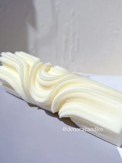 The wave twisted candle lying on its side, showing the continuous flow of the design.