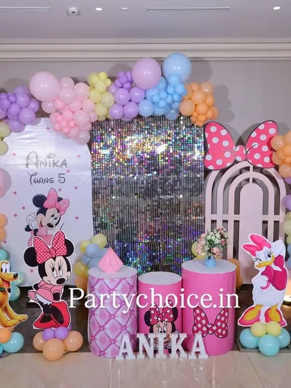 This Minnie Mouse birthday party is a pastel dream. The setup includes a shimmering sequin panel, a custom arch, and character cutouts of Minnie, Daisy, and Pluto, all tied together with a soft, multi-colored balloon garland.