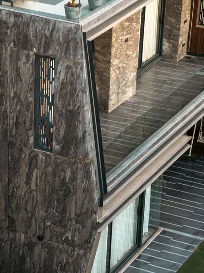 An aerial detail of the Club Drive House, showing the angled geometry and the relationship between the balcony, terrace, and the small green space below.