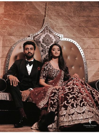 A regal portrait of the couple seated on a throne-like chair, exuding power and elegance.