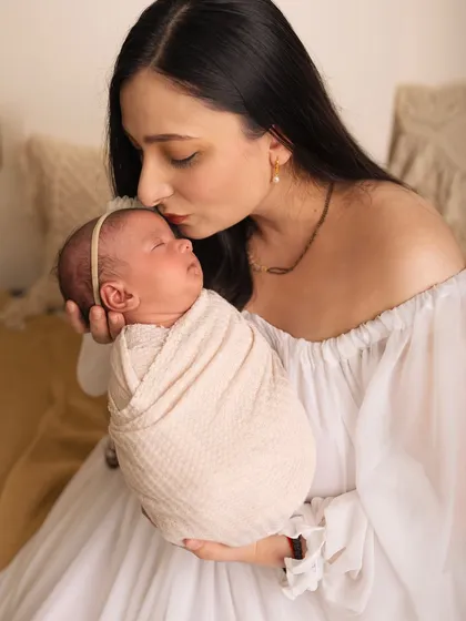 A mother's tender kiss for her sleeping newborn. These moments are so fleeting, and I feel honored to preserve them for you.