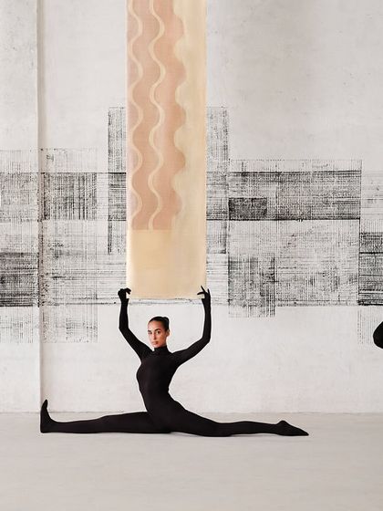 Models in black catsuits interact with suspended Banarasi textiles, showcasing the fabric's lightness and color in a dynamic, gravity-defying way.