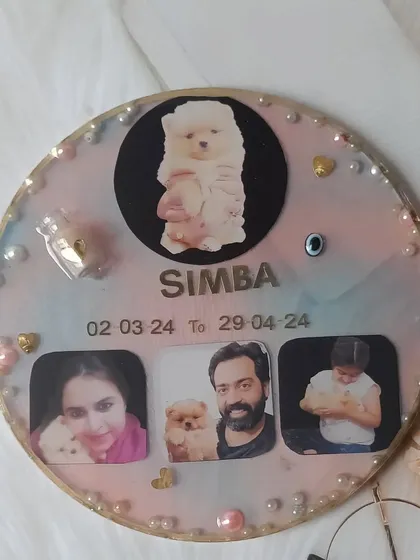 A beautiful memorial plaque for a beloved puppy named Simba. This piece includes his photos, name, dates, and a small bottle with his preserved hair, creating a touching tribute for the family.
