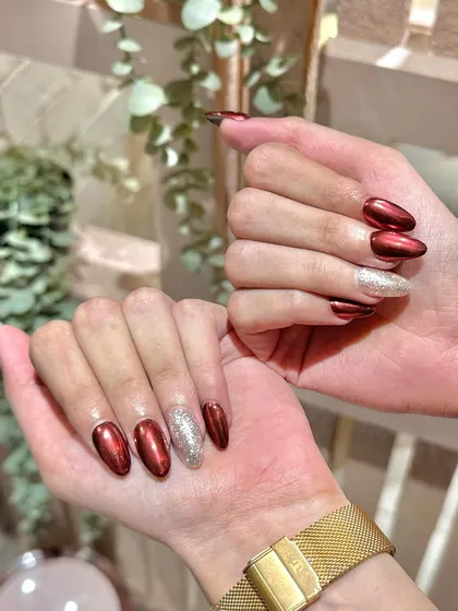 Get into the festive spirit with these stunning red chrome nails, accented with a sparkling silver glitter nail. Perfect for the holidays!