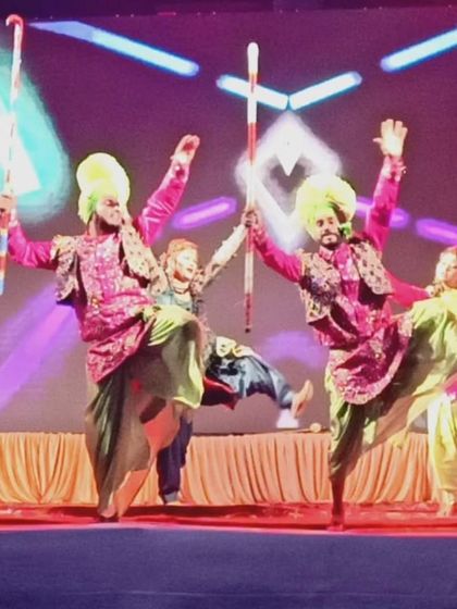 Our Punjabi dancers in action on stage, showcasing their high-energy moves and traditional props.