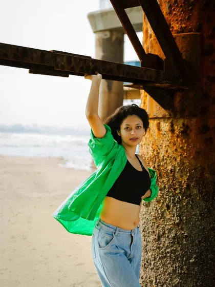 Holding onto the pier structure, this pose feels both strong and playful. The natural light filtering through is perfect.