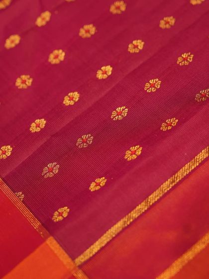 The fine texture of the maroon Kanjivaram, showing the delicate lines of the weave.
