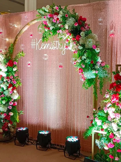 Another version of the "#Kemistry" photo backdrop, this time with a shimmering pink sequin wall and a beautiful arch of red and white flowers.