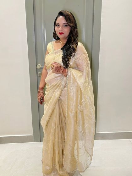 A full-length shot of the client in her golden saree.