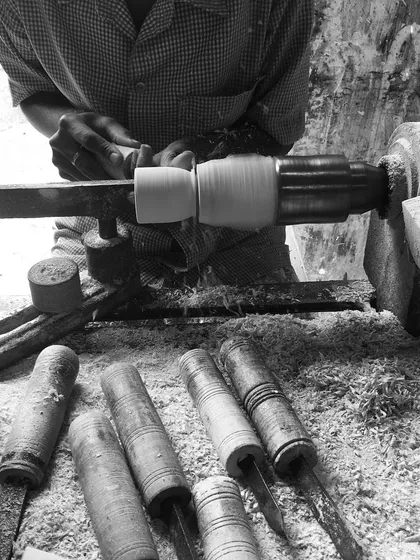 This image captures the essence of our craft. An artisan, focused and skilled, works at a traditional lathe, surrounded by wood shavings and the tools of the trade. This is a scene that has been part of Channapatna's identity for centuries.