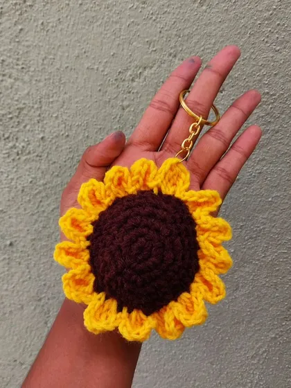 Carry a little sunshine with you with this handmade crochet sunflower keychain. The detailed petals and rich brown center make it a cheerful addition to any set of keys.