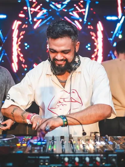 A great shot of me at the decks during the Innellea afterparty, with the vibrant visuals of Kitty Su in the background.