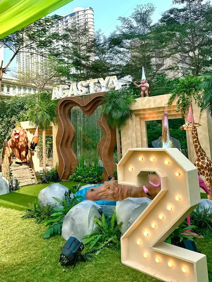 For this 'Wild Two' jungle themed birthday, we created a massive custom stage with marquee letters, a waterfall feature, and life-sized animal props to serve as the perfect backdrop for the celebration.