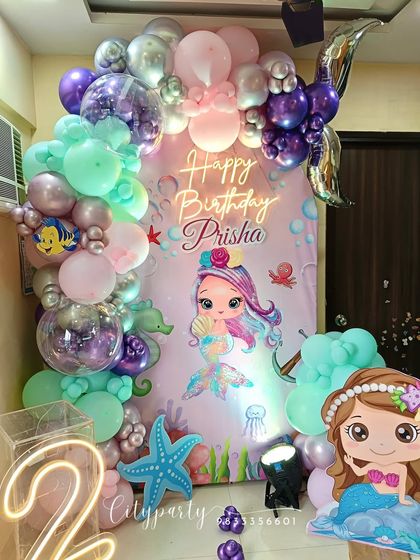 A full view of the mermaid-themed home decoration, showing the complete balloon arch and backdrop setup.