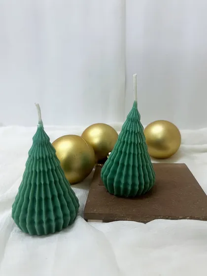 Happy Christmas. Our green spiky Christmas tree candles, styled with golden ornaments for a festive look.