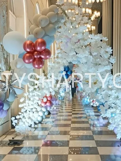 We design immersive experiences, like this tunnel entrance for a Frozen-themed party. The pathway is lined with illuminated white trees and balloon arches, creating a magical winter wonderland that transports guests straight into the fairytale.