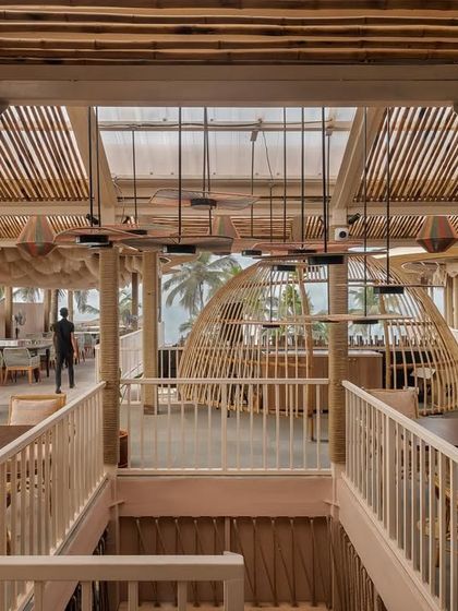 A view from the upper level of Dubki, looking down into the main space. The use of bamboo, rope, and wood creates a cohesive, nature-inspired aesthetic that connects the different levels.