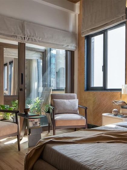 A bedroom corner at Urban Oasis offers a serene retreat where tranquility and craftsmanship converge. Light streams in from the adjacent court, blurring the lines between indoor and outdoor living.