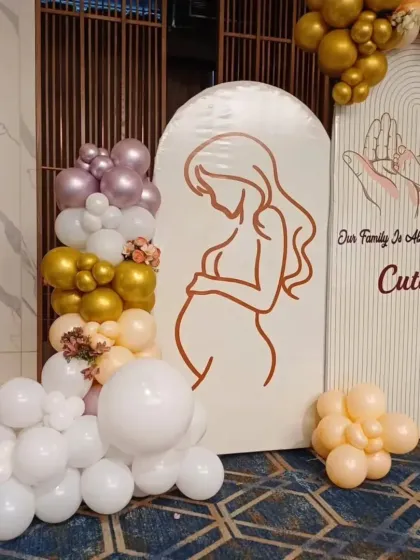 A close-up of the arched backdrop for the baby shower, showing the beautiful line art of the mother-to-be.