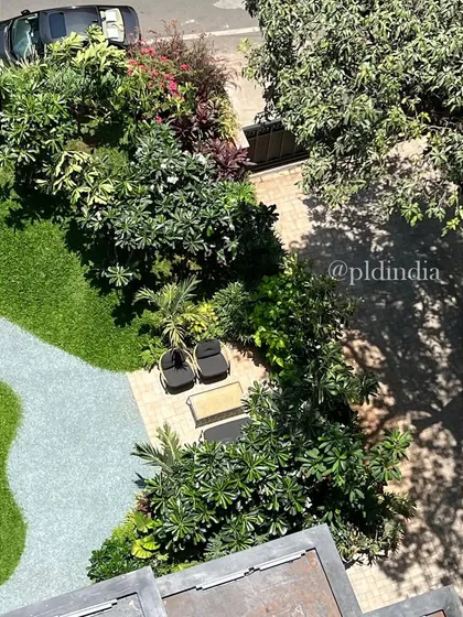 A close-up aerial view of the seating nook in the entrance garden. The space is designed to feel intimate and private, even within a larger, shared landscape.