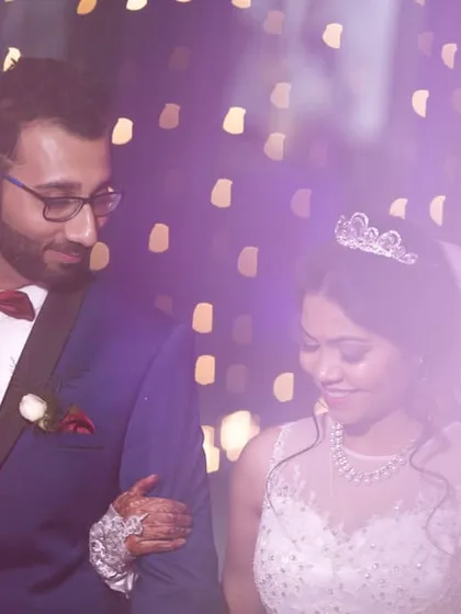 A candid moment from a beautiful Christian wedding. The groom looks at his bride with so much love as they walk together, bathed in the soft, dreamy light of their reception.
