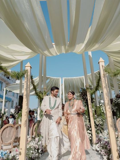 The happy couple walks down the aisle, framed by the petal-like canopy ceiling. This design was both functional for shade and aesthetically beautiful, blending seamlessly with the natural environment.
