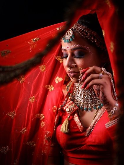A close-up shot of the bride holding her nath. The intricate details of the eye makeup and the 'bindi' are highlighted here.