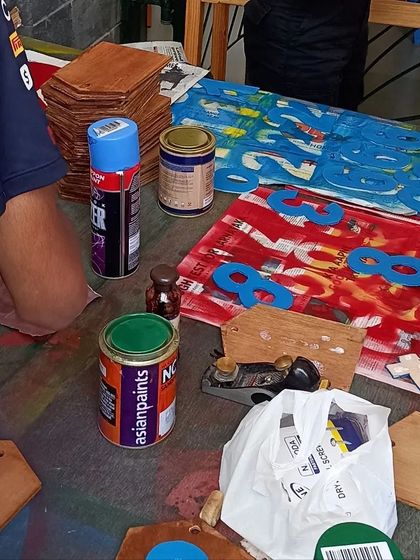 The painting and finishing stage of the scoreboard project. The numbers are painted in house colors before being attached.