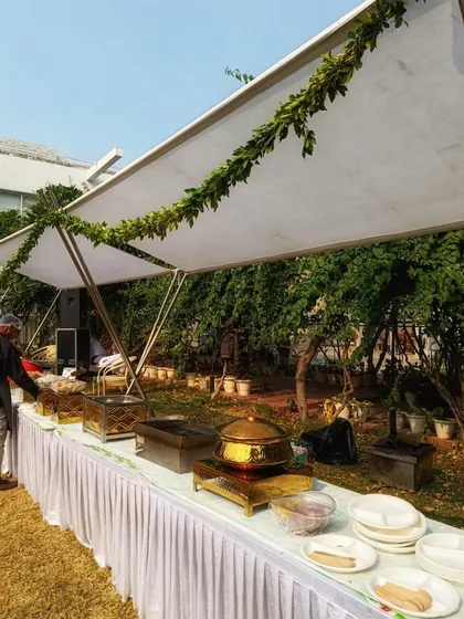 My decor services extend to outdoor catering setups to ensure a consistent aesthetic. For this daytime event, I used a clean, white canopy elegantly draped with simple green foliage to create a fresh and sophisticated dining area.