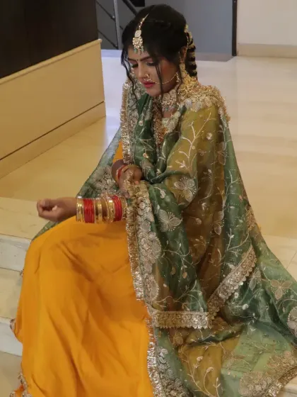 This pose highlights the rich colors and textures of the bridal lehenga and the complementary makeup.