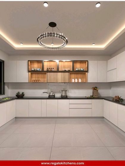 A minimalist U-shaped kitchen with clean white cabinets and a contrasting black countertop. The open wooden shelves add a touch of warmth and provide display space. This design is all about simplicity and functionality.