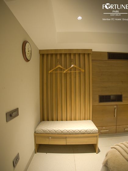 We provide practical storage solutions in every room, like this cushioned luggage bench with drawers and a dedicated space for hanging clothes.