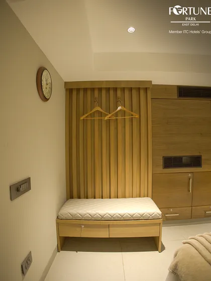 We provide practical storage solutions in every room, like this cushioned luggage bench with drawers and a dedicated space for hanging clothes.