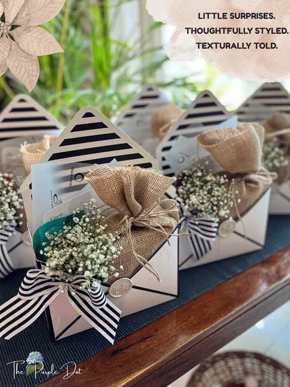 Even small surprises can hold big moments. These envelope-styled boxes blend rustic burlap with chic stripes, finished with a wax seal and a sprig of baby's breath. They are perfect for party favors or small, meaningful gestures.