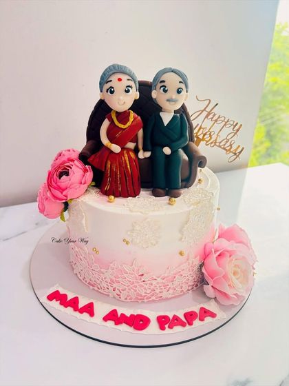 Handcrafted with love for Maa and Papa. This anniversary cake features adorable custom fondant figures of the couple.
