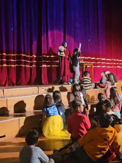 A young volunteer reading from a script on stage. I love giving kids a chance to shine and be part of the comedy.