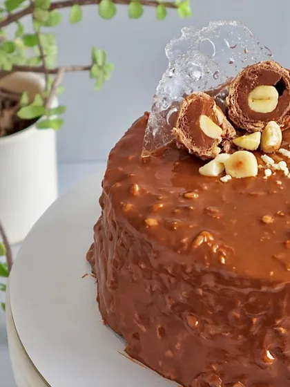 This is my signature Almond Rocher Cake, and it's a bestseller for a reason. It has layers of rich chocolate sponge and Nutella ganache, all wrapped in a crunchy almond chocolate glaze. It’s pure indulgence with a satisfying crunch in every bite.
