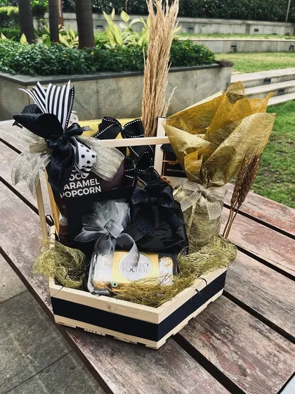 The ultimate surprise for a team or client. This hamper is generously filled with gourmet popcorn and other treats, all styled with a sophisticated black, white, and gold color scheme.