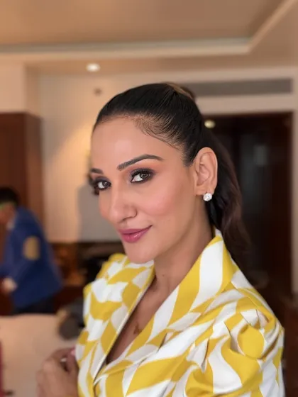 A portrait of the client with her hair in a high ponytail, a sleek and confident look for a modern event.