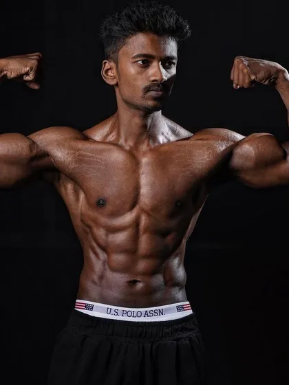 A classic double biceps pose from my client after his incredible transformation. This demonstrates the significant muscle mass and definition he built.